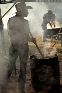 Stirring the beans in a 50 gallon cast-iron wash pot in Millheim, TX at a community BBQ